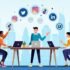 Affordable social media marketing agency team working on laptops with digital icons, Dubai skyline in background – Growvoo.